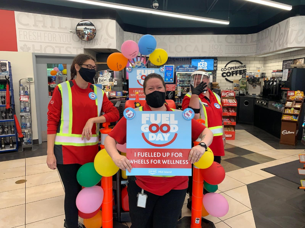 Staff hold up a Fuel Good Day sign and smile