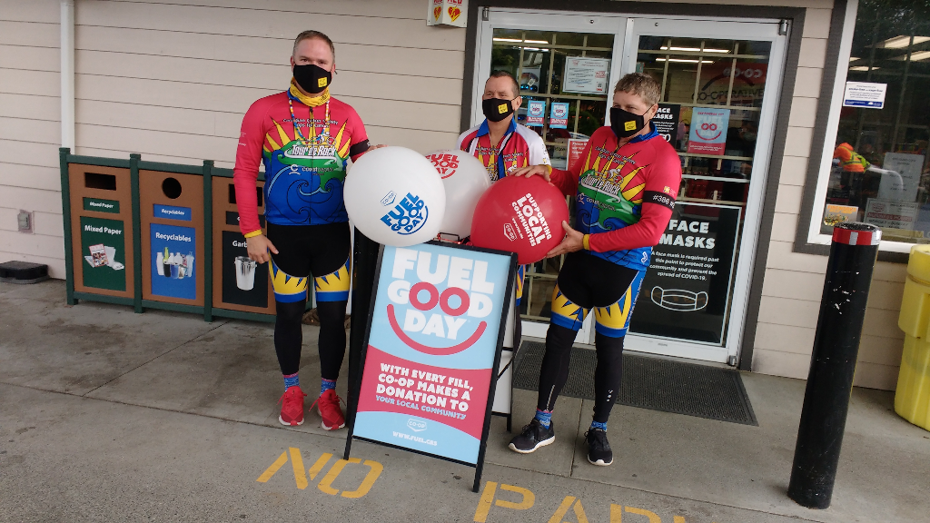 Customers pose with a Fuel Good Day sign and balloons